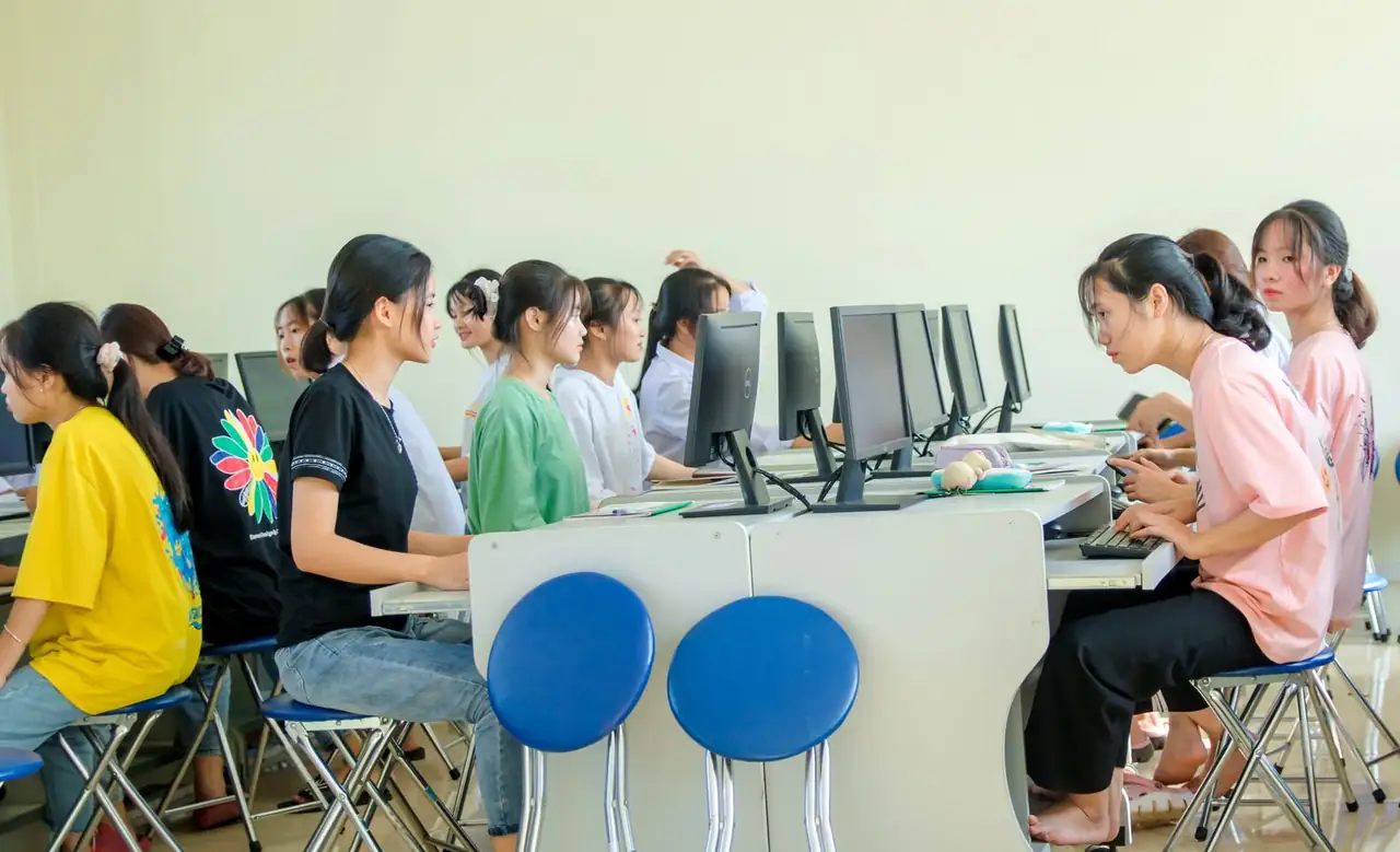 Students in an educational technology lab collaborating on technical assignments