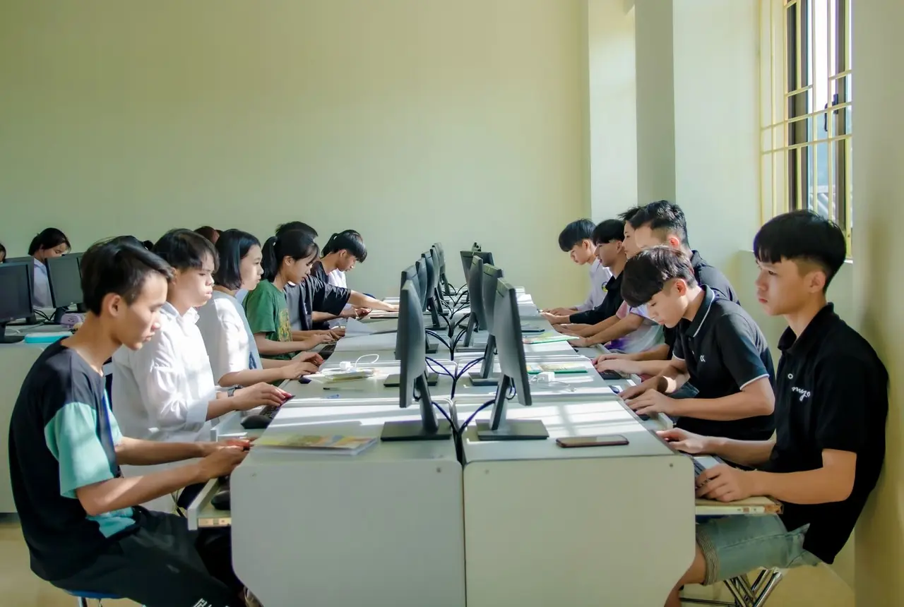 Adult learners in a technology classroom engaged in practical digital coursework