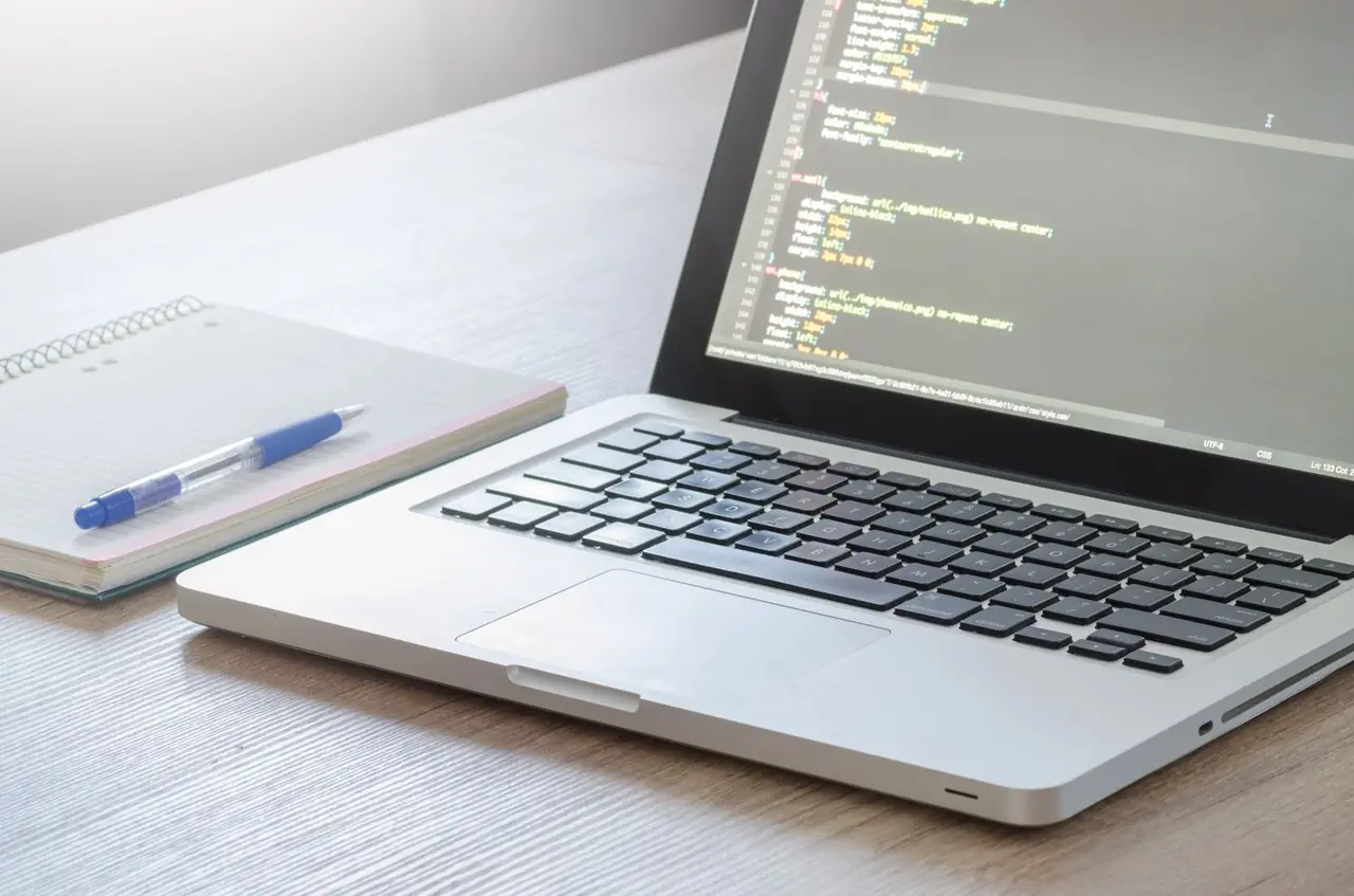 Data analyst workstation with structured datasets, notebook, and analytical laptop